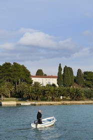 Croatia, Dalmatia, Dalmatian Coast, Ugljan Island, Preko, Franciscan friar Bozo Susic rejoining the Franciscan Monastery of the Galovac island on his boat