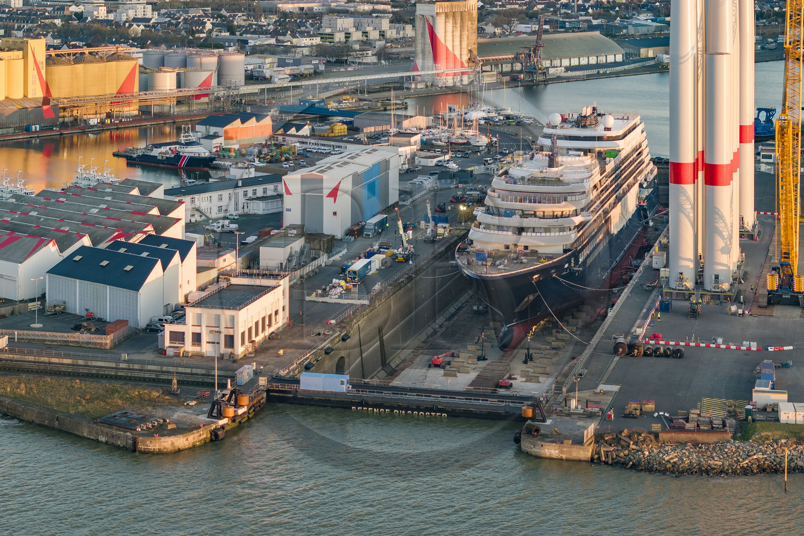 France, Loire Atlantique, Saint Nazaire, the construction site of the luxury super-yacht Ritz-Carlton Luminara in the Joubert dry dock, the wind turbine towers on the right are stored before embarkation (aerial view)