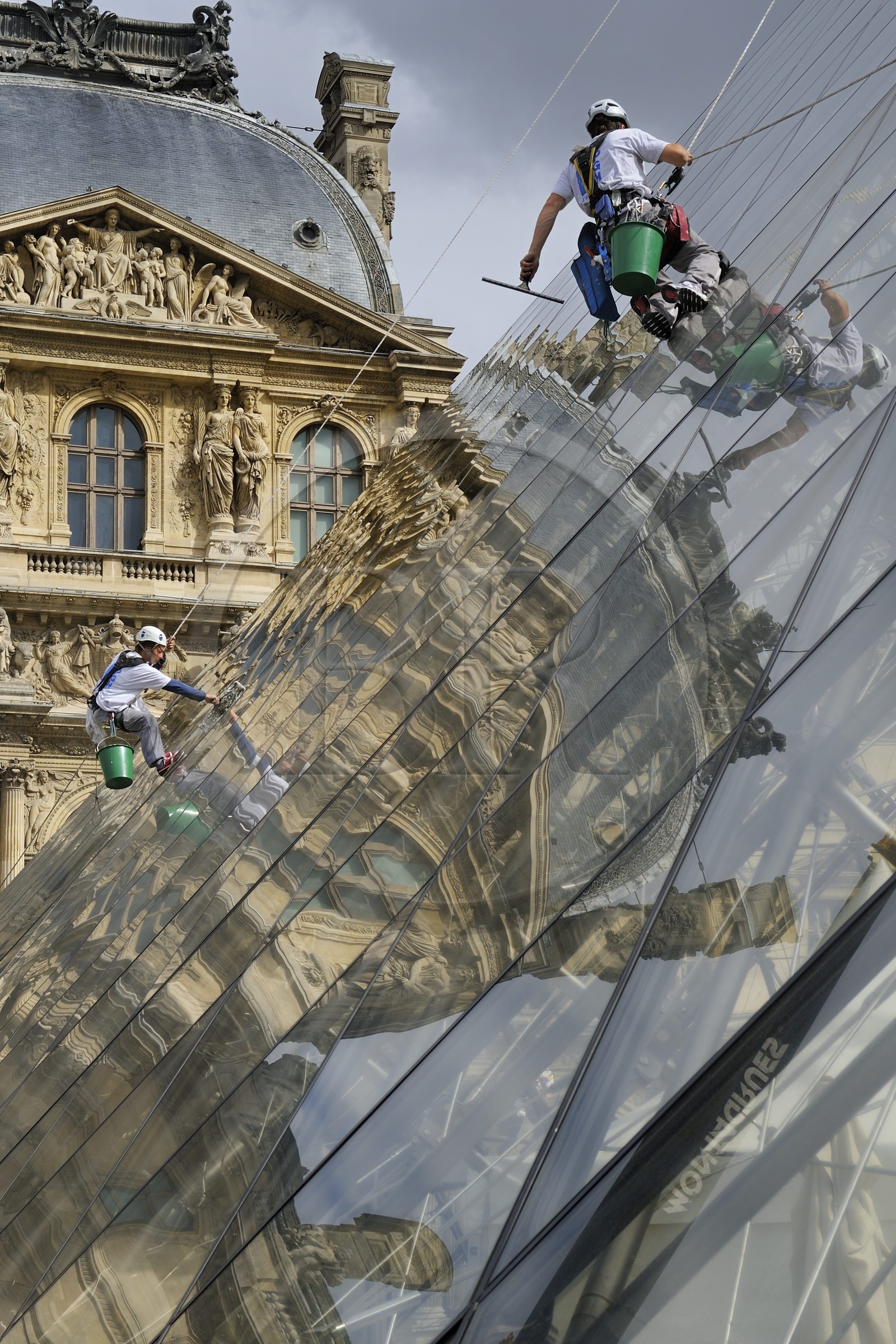France, Paris, Louvre Museum, window cleaners on the glass facade of the Pyramid by the architect Ieoh Ming Pei