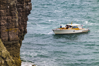 France, Côtes d'Armor (22), Grand Site de France Cap d'Erquy – Cap Fréhel, Plévenon, touriste en bateau au pied de la falaise du phare du Cap Fréhel