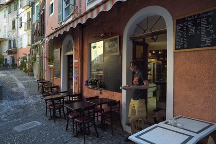 France, Alpes-Maritimes, Roya Valley (Nice hinterland), at the foot of the Mercantour National Park, Saorge, Jerome Lion in front of his grocery-bistro the Petite Epicerie in the early morning