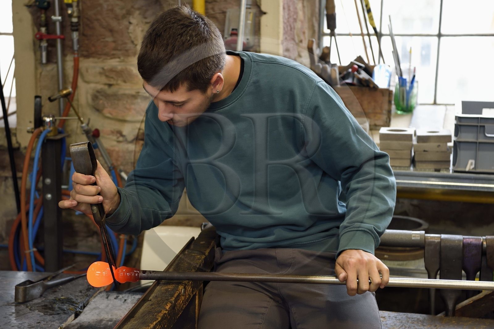 France, Moselle, Meisenthal, Centre international d'Art verrier (CIAV) (international glass centre), the blowing workshop, crafting a Christmas ball, the prompter regulates the mass at home plate while performing a continuous rotation of his cane and preparation of the parison before passing to the mold