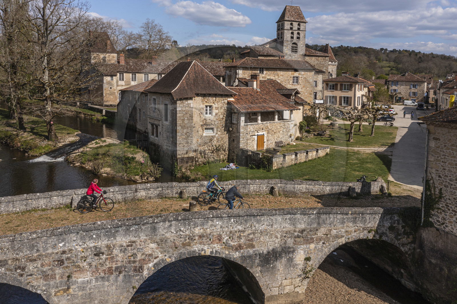 France, Dordogne (24), Périgord Vert, Saint-Jean-de-Côle, labellisé Les Plus Beaux Villages de France, cyclistes faisant la véloroute la Flow Vélo franchissant le pont médiéval du XIIème siècle, le clocher de l'église Saint-Jean-Baptiste (vue aérienne)