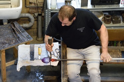France, Moselle (57), Meisenthal, Centre international d’Art verrier (CIAV), l'atelier de soufflage, fabrication artisanale d'une boule de Noël, façonnage à la sortie du moule de soufflage par le maitre verrier Jean-Marc Schilt