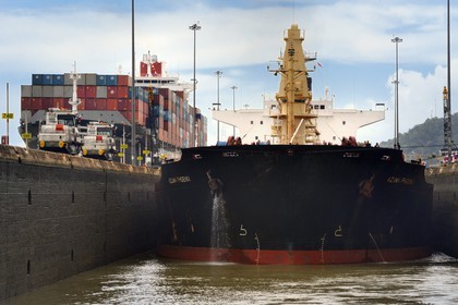 Panama, Canal de Panama, écluses de Miraflores, mules mécaniques ou locomotives électriques guidant un cargo Panamax entre les murs de l'écluse