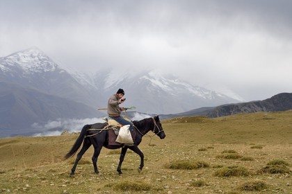 Azerbaijan, Quba (Guba) region, Greater Caucasus mountain range, summits in the clouds in the heights of the village of Giriz, breeder on horseback