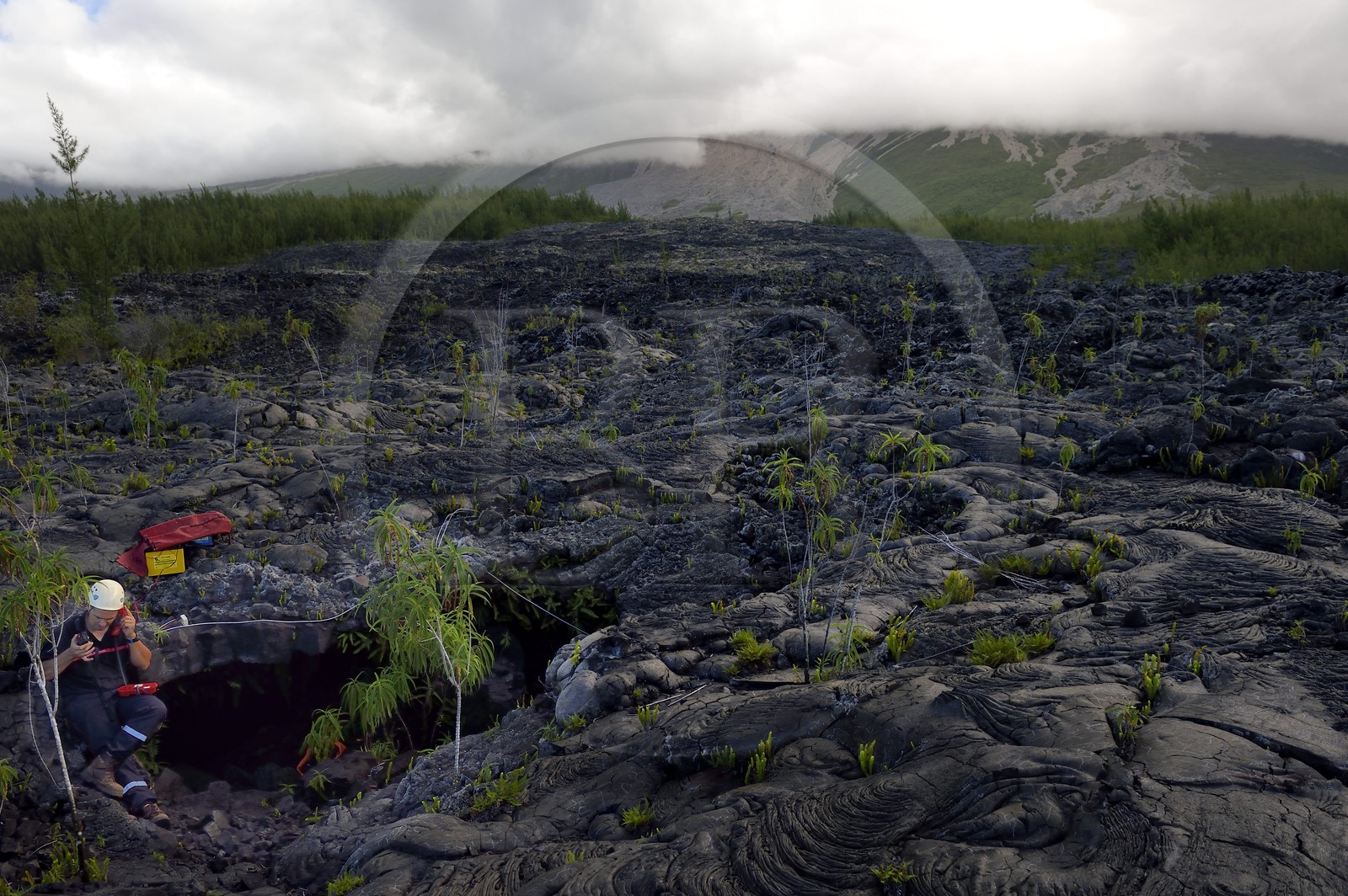 France, Ile de la Reunion, volcan du Piton de la Fournaise, classé Patrimoine Mondial de l'UNESCO, le Grand-Brûlé, coulée de lave récente au pied du volcan, pompier à l'entrée d'un tunnel de lave à l'occasion d'un exercice de sauvetage
