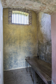 France, Guyane, Saint-Laurent-du-Maroni, bagne ou Camp de la Transportation, les quartiers disciplinaires, intérieur d'une cellule individuelle, planche lit sur laquelle les pieds du bagnard était entravés