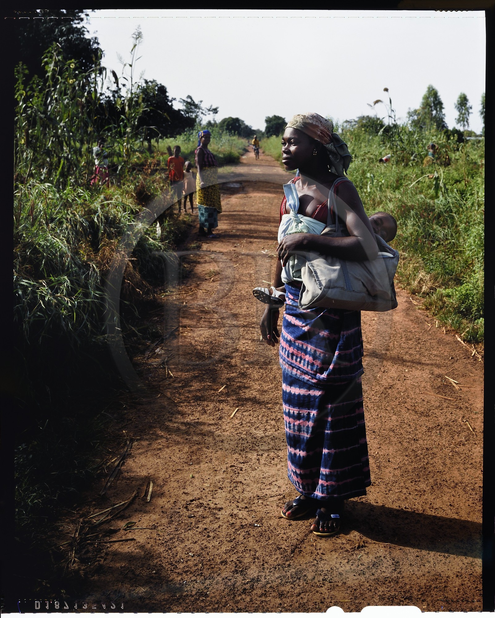 Burkina Faso, province de Poni, pays des Lobi, jeune mère Lobi portant son enfant sur la piste de Gaoua à Loropéni