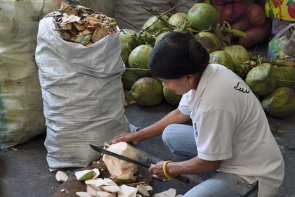 Philippines, province d'Ifugao, découpe d'une noix de coco dans le marché de la ville de Banaue
