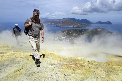 Italie, Sicile, iles Eoliennes, classées Patrimoine Mondial de l'UNESCO, ile de Vulcano, randonneurs dans l'ascension du cratère du volcan della Fossa à travers les fumerolles soufrées, l'Ile de Lipari en arrière plan