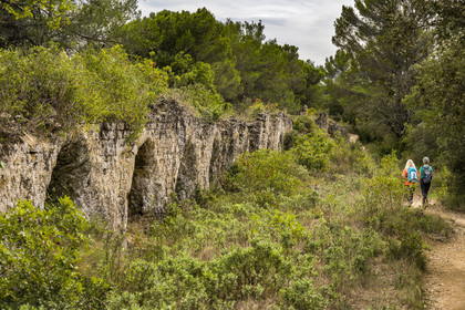 France, Gard (30), Vers-Pont-du-Gard, randonneurs longeant les vestiges de l'aqueduc romain de plus de 52 km de longueur qui amenait l'eau de la Fontaine d'Eure au pied d'Uzès jusqu'à Nimes en passant sur le Pont du Gard
